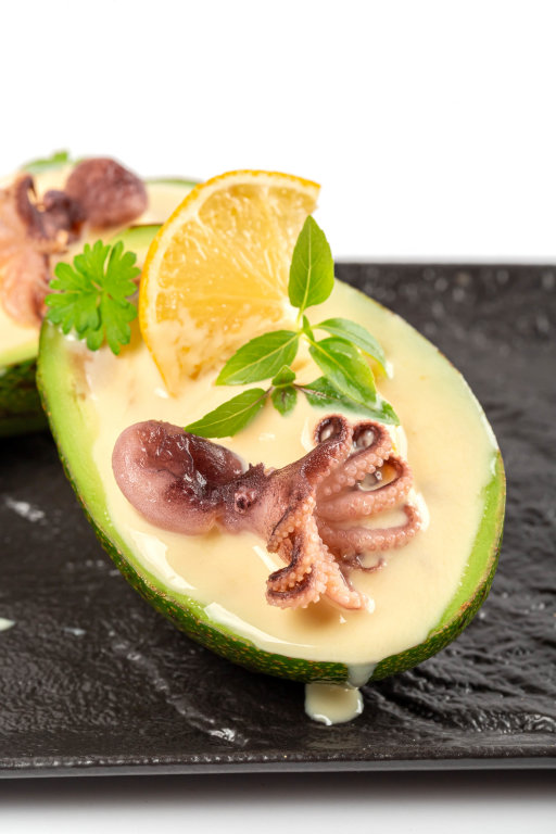 Avocado with octopus and cream sauce, close-up
