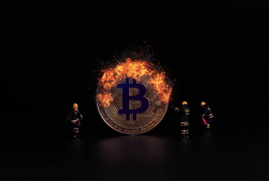 Bitcoin on fire and miniature firefighters