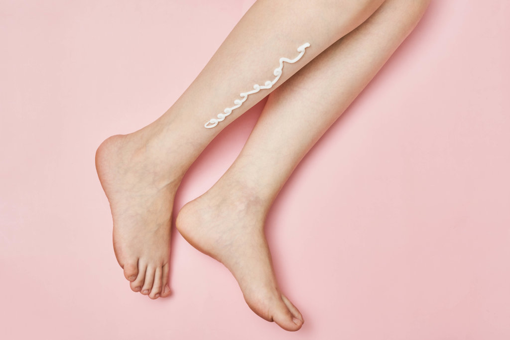 Female leg with the applied skin moistening cream