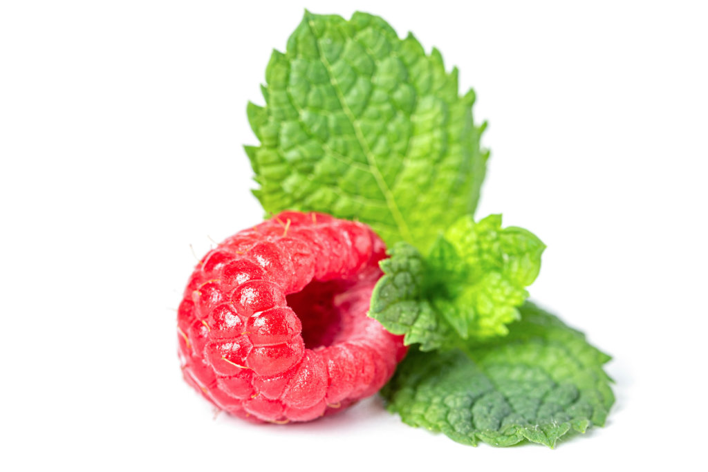 Raspberry berry and mint leaves, close-up on white