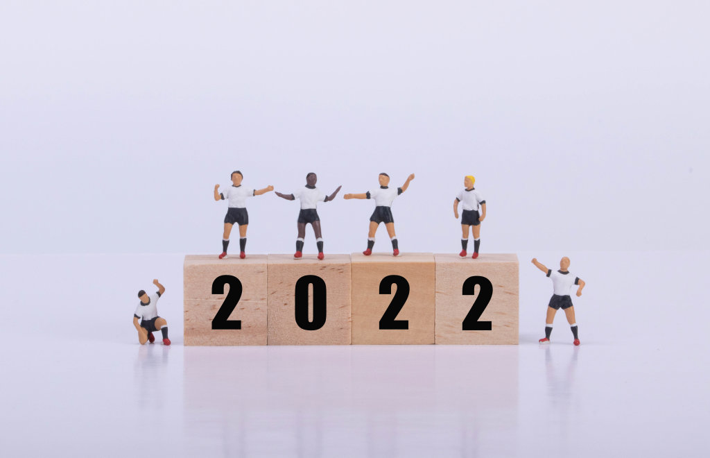 Soccer players standing on wooden cubes with 2022 text
