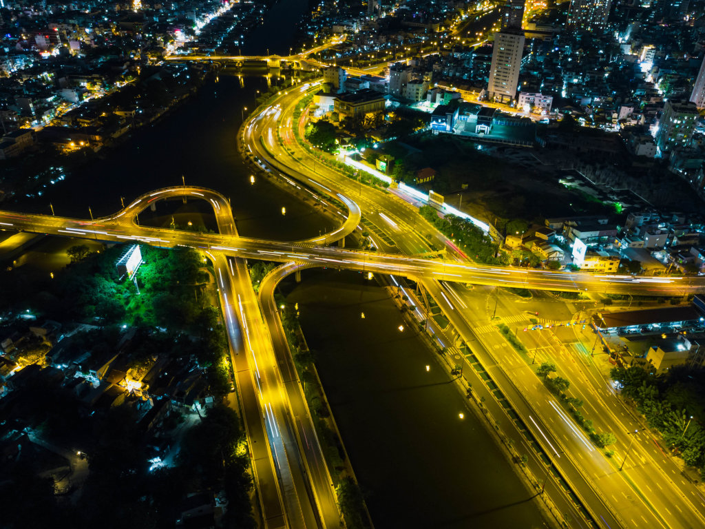 Langzeitbelichtung von einer Brücke welche 3 Stadtbezirke verbindet aus der Luft mit einer Drohne bei Nacht in Ho Chi Minh Stadt, Vietnam