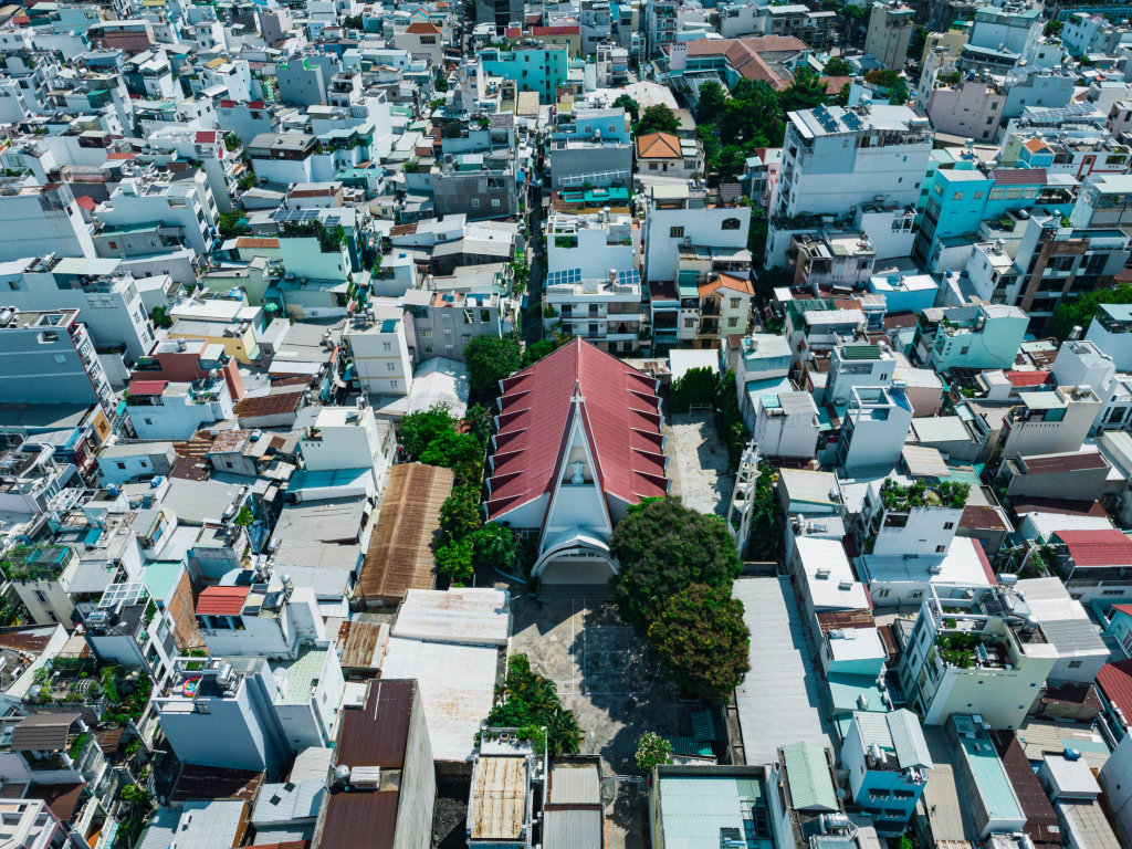 Bird View Drone Photo of a local Catholic Church within a Residential Area with many Houses and Alleys in Ho Chi Minh City, Vietnam