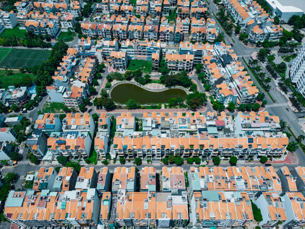 Top View Drone Photo of Identical Houses in a Residential Area with Football Fields and Lake in District 7 in Ho Chi Minh City, Vietnam