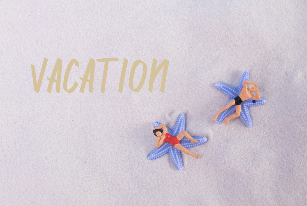 Couple relaxing at sandy beach with Vacation text