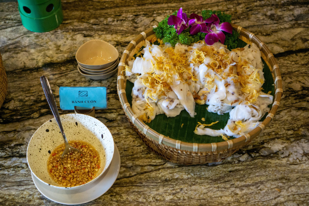 Top View Food Photo of Vietnamese Rice Rolls Banh Cuon with Fried Onions next to a Bowl of Fish Sauce with Garlic and Spices at a Breakfast Buffet at a Hotel in Vietnam