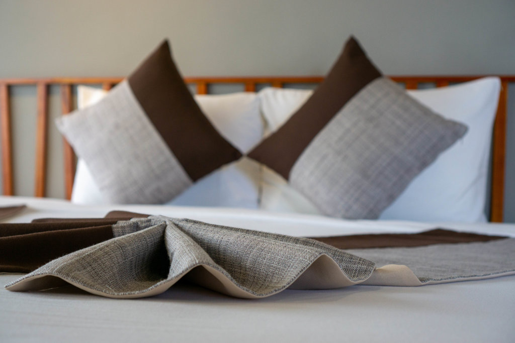 Close Up Photo of Creative Folded Bed Runner on a Large King Size Bed in a Hotel Room