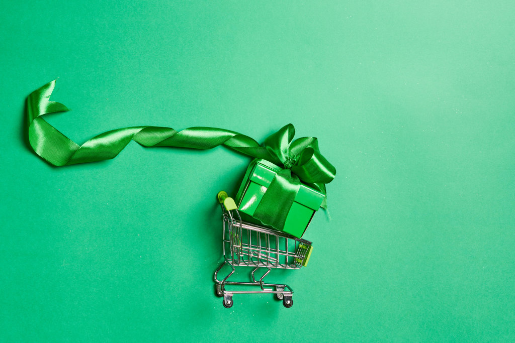 A green giftbox in the shopping cart. Top view