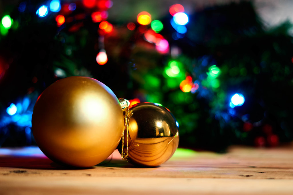 Two golden Christmas tree balls on wood