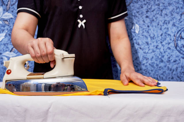 Young female ironing a cloth