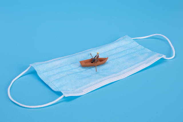 Man in a boat on medical face mask