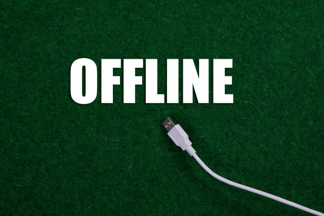 USB cable and Offline text on green grass