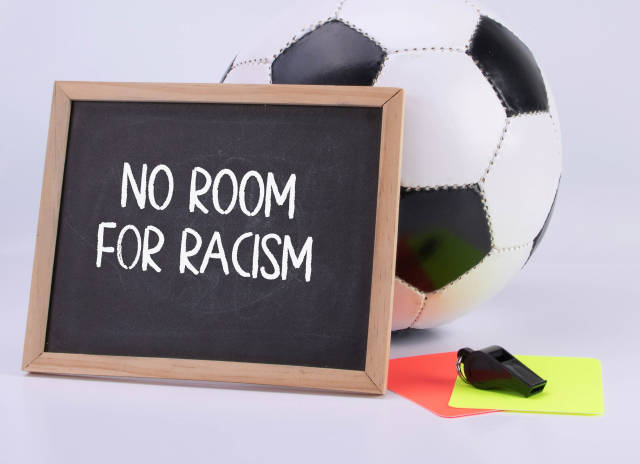Soccer ball, referee cards and chalkboard with No room for racism text