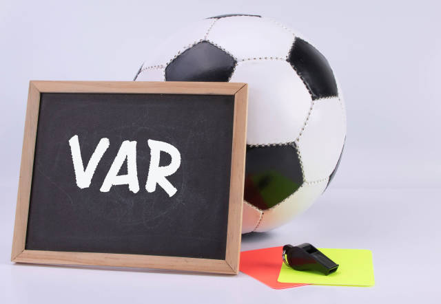 Soccer ball, referee cards and chalkboard with VAR text