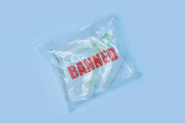 A transparent bag full of plastic sing-use mugs with Banned stamp