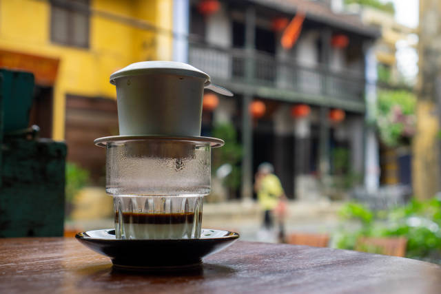 Heißer Traditioneller Vietnamesischer Filterkaffee mit gezuckerter Kondensmilch in einem Glas in einem Cafe in der Altstadt von Hoi An, Vietnam