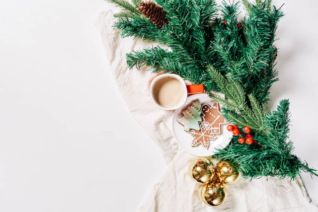 Branch of pine tree, Christmas baubles, cookies and cup of coffee on white background