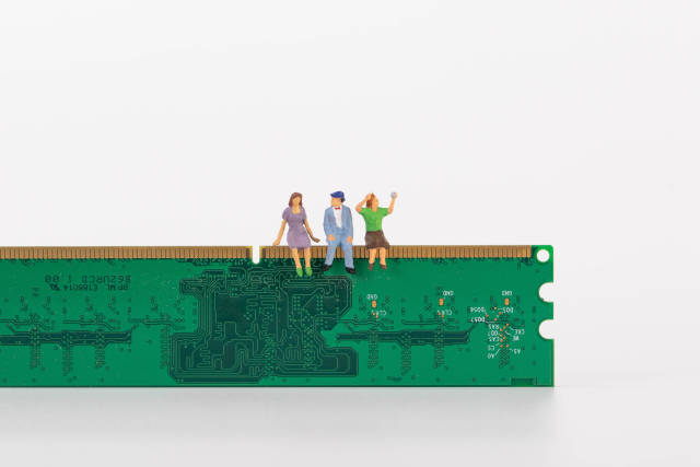 Group of miniature people sitting on a computer chip