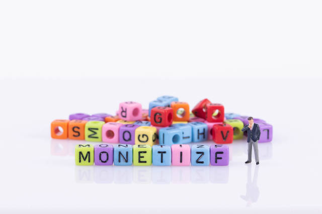 Businessman with colorful toy blocks with Monetize text