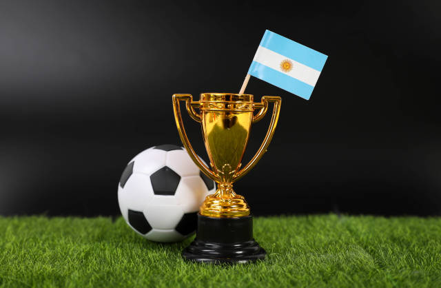 Golden trophy and football ball with flag of Argentina