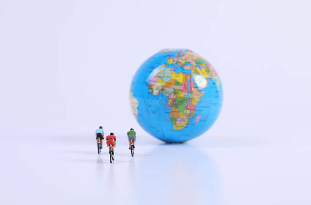 Miniature Figures Ride Bicycle on globe and Cycle to Work Day text