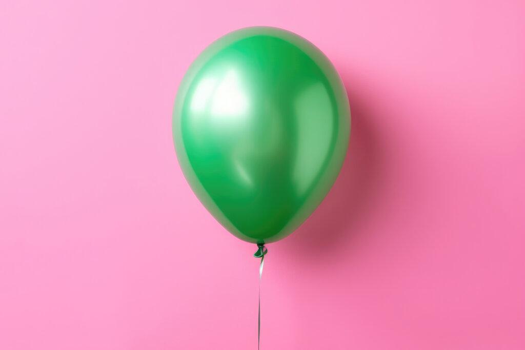 grüner Luftballon auf pinken Hintergrund