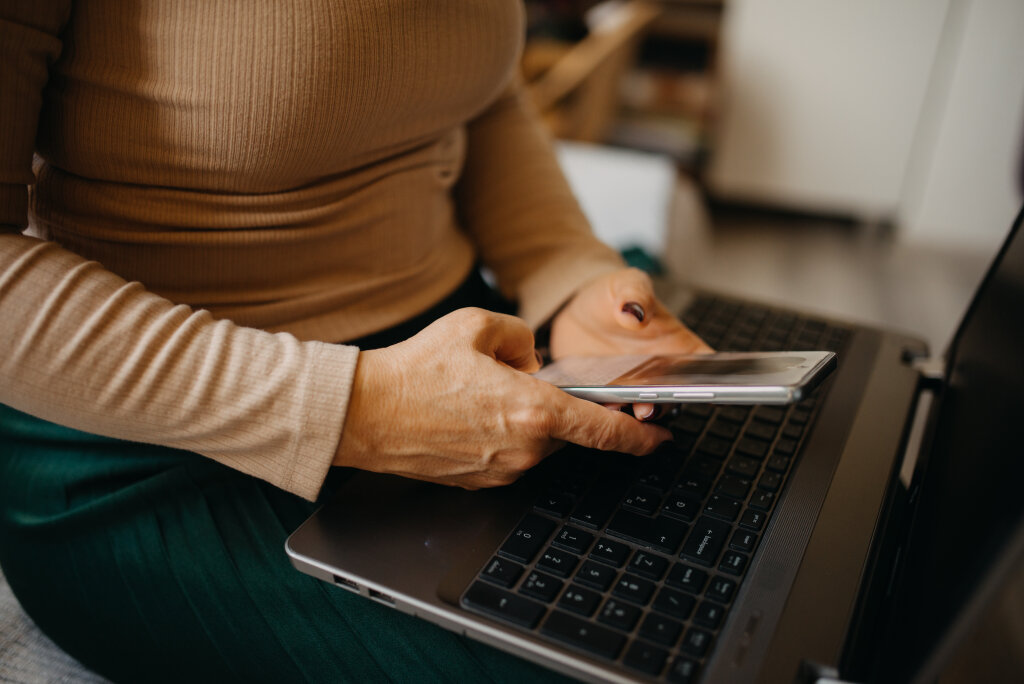 Middle-aged woman using a smartphone at home closeup
