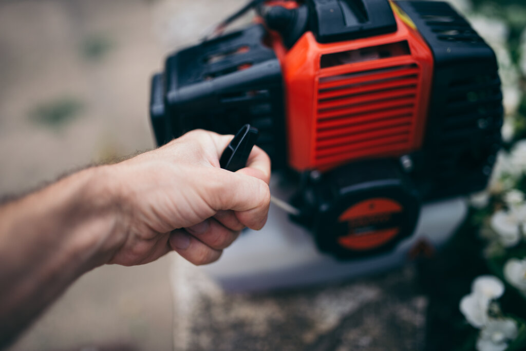 Man starting a lawn trimmer.