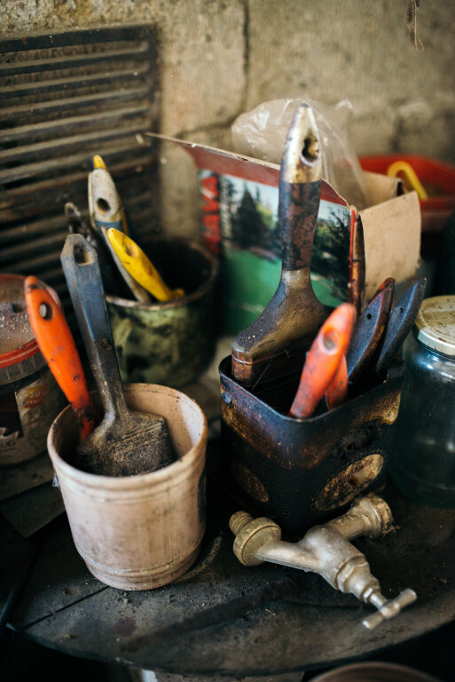 Different colorful brushes in the buckets on the table.