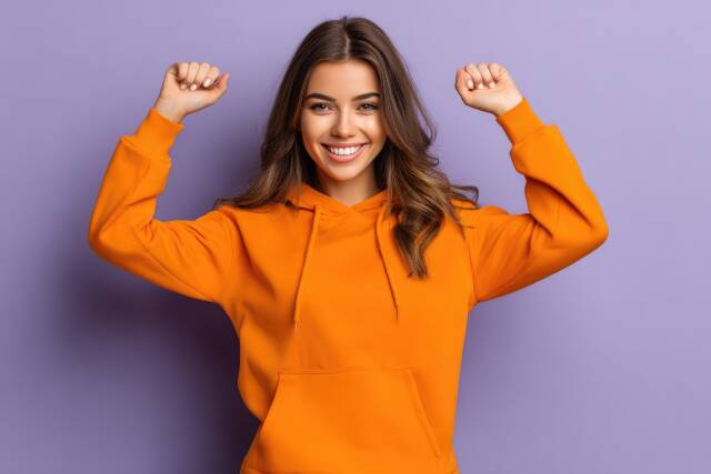 Fröhliche junge Frau im orangefarbenem Hoodie