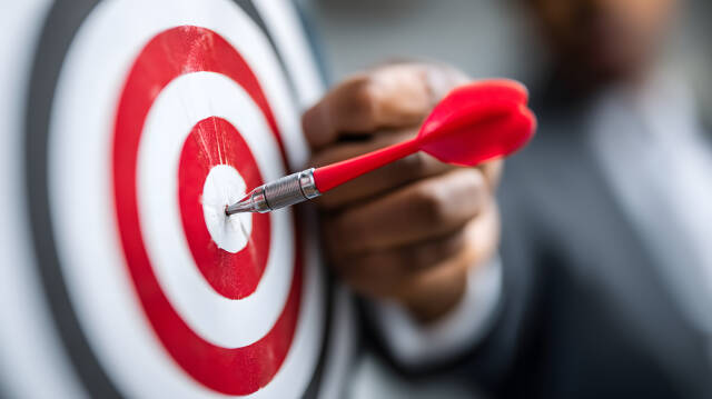 Businessmann trifft Ziel mit Dartpfeil