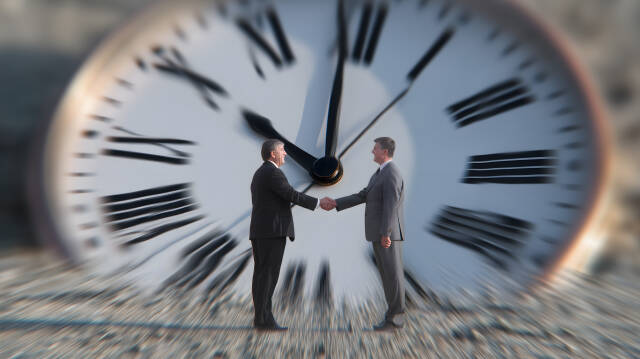 Geschäftsleute schütteln Hände vor riesiger Uhr