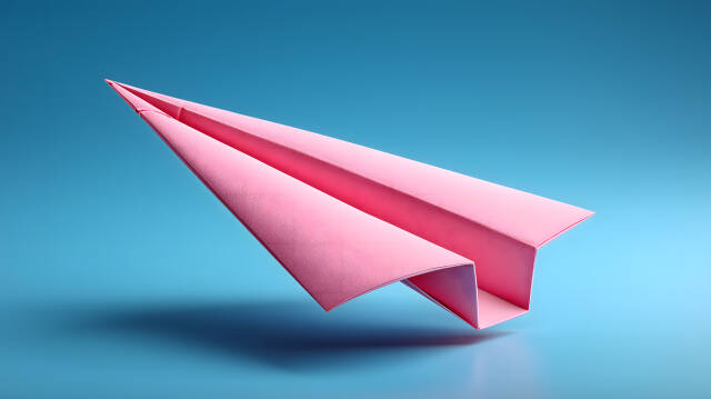 Pinkes Papierflugzeug vor blauem Hintergrund minimalistisch