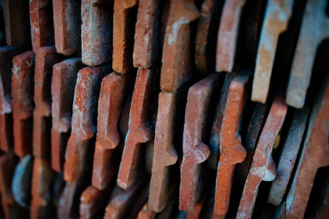 Old rusty tiles are lying in a stack closeup.