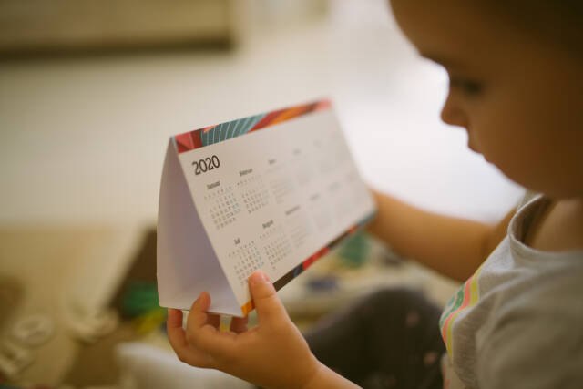 Young girl holding calendar.