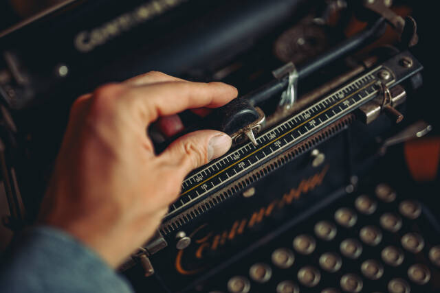 A man's fingers on a typewriter. Andjustment concept.