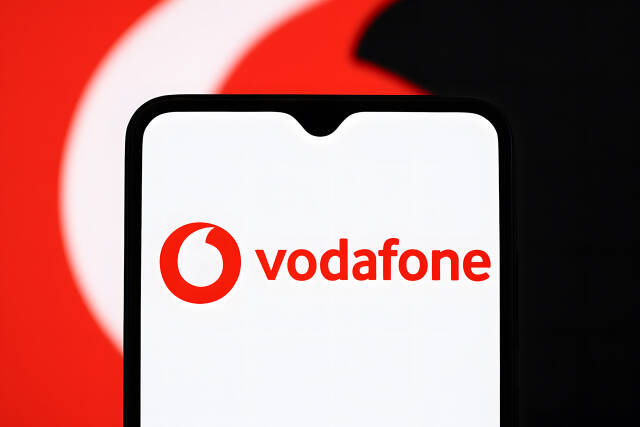 Vodafone Logo auf Smartphone vor rotem Hintergrund Mobilfunkanbieter