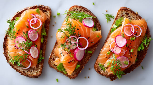 Drei Lachs Sandwiches mit Radieschen und Dill auf Marmorplatte