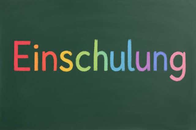 Einschulung mit bunter Schrift auf Schultafel