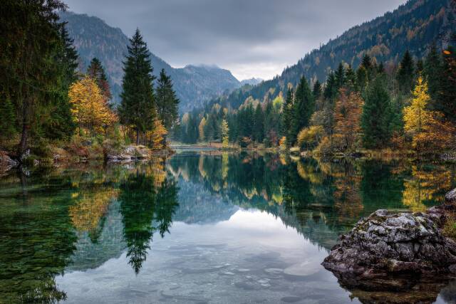 Herbstlandschaft mit See und bunten Bäumen in den Alpen