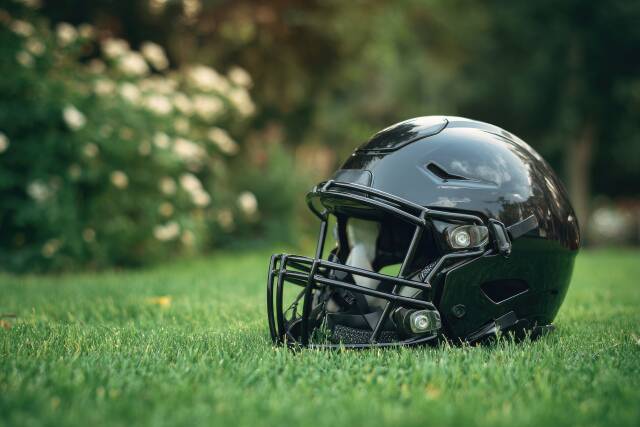 Schwarzer Footballhelm auf Rasen