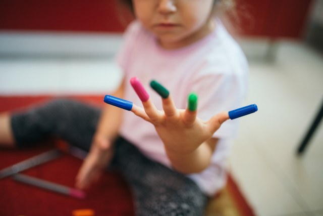 A cheerful girl sits on a soft rug