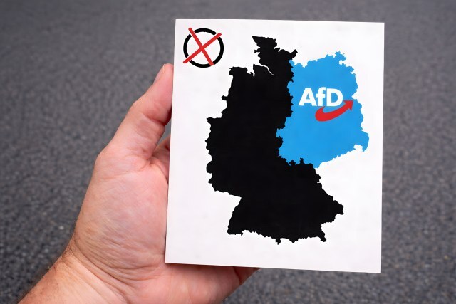 Wahlen: Hand hält Karte von Deutschland mit AfD Symbol im Osten
