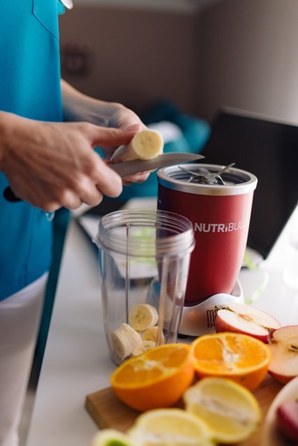 Preparing fresh fruit for a smoothie in a modern kitchen