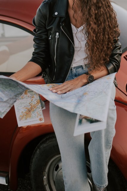 Exploring new destinations with a map and vintage car at sunset