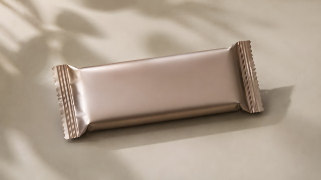 Glänzende Süßigkeitenverpackung auf beigem Untergrund